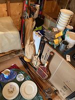 Photo showing golf clubs in bags, golf accessories, and white bowls on a table