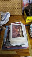 Stack of photo greeting cards with visible bird landscape print, sitting on a wooden surface with other miscellaneous items