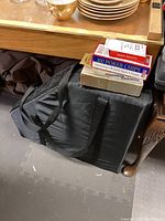 Poker chips and playing cards on top of a black soft carrying case for the poker table set.