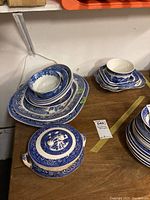 Stacked blue and white rectangular, oval plates and bowls with one covered tureen with lid