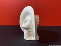 Side view of the white ceramic bust showing lady's head with large hat