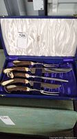 Full view of six-piece carving set inside blue vinyl covered box showing satin lining and arrangement of utensils