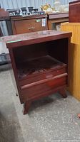Front angled view of the wooden side table showing open compartment and drawer beneath.