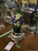 Frontal view of ceramic lamp body and ornate brass-tone base without shade