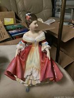 Front view of Royal Doulton Southern Belle figurine with red gown and detailed porcelain finish.