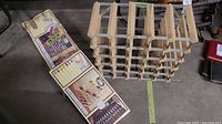 Wooden expandable wine rack and two unopened boxes for matching racks.