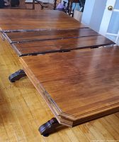 Table partially extended showing two leaves in rail mechanism