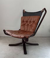 Front three-quarter view showing leather seat, back sling, missing headrest cushion.