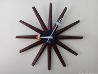 Full front view of the George Nelson style sunburst clock with wooden rays on a white wall.