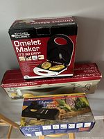Photo of Kitchen Gourmet Omelet Maker box on top of Tools of the Trade Food Dehydrator box and Starfrit Supreme Slicer box