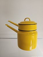 Side view of stacked yellow double boiler pots with lid on top.