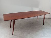 Full view of table showing surfboard-shaped top and four tapered legs