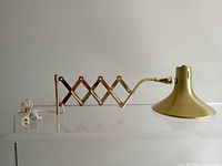 Side profile showing extended scissor arm and conical shade from left side.