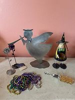 Full lot showing angel figurine, witch figurine, metal flower art, Mardi Gras beads, and corkscrew with 2000 decoration