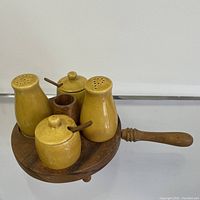 Full view of the vintage kitchen condiment set on wooden tray showing shakers, condiment jars, and toothpick holder