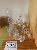 Photo showing all six glass figurines displayed together on wooden shelf.