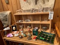 Full lot overview showing glass items, eggs, stones, and plate arranged on shelf and chair