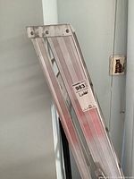 Full view of folded aluminum ladder showing its height and structure.