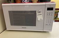 Front view of the Panasonic microwave showing brand and control panel with product tag.