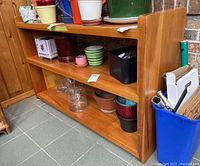 Pine shelving unit displayed with various pots and containers on shelves, demonstrating size and style. Shelf has visible wear and tear.