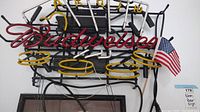 Front view of Budweiser neon beer sign with American flag attached on the right side.