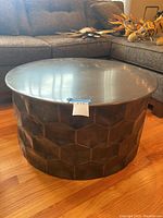Full view of round metal table with hammered texture side and smooth top surface.