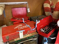Photo shows Milwaukee heavy-duty sawzall metal case and other red metal tool boxes on a shelf.