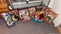 Overview photo showing 8 boxed action figures including Soldier of the World WWII soldier, Bruce Lee, and GI Joe figures, some with damaged boxes.