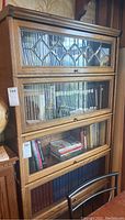 Full view of four-section oak barrister bookcase with glass doors and brass knobs