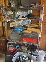 Front view of metal wire shelving unit with various workshop items stored on shelves.