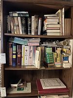 First bookshelf containing rows of reference and non-fiction books, some stacked horizontally and others vertically.
