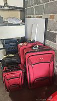 Four luggage bags grouped together showing size comparison and colors