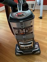 Front view of the Shark Navigator upright vacuum showing the brand label, dust cup, and base