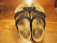 Top view of the used black Birkenstock sandals showing footbeds and straps.