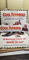 Wide view of the folded Cool Runnings movie poster and lobby insert with John Candy promotional photo and insert cards on an easel.