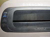 Top control panel of Fellowes 1210c shredder showing indicator lights and feed slot.