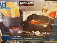 Box image showing original 15-piece Kirkland Signature hard anodized aluminum cookware set with visual of various pots and pans.