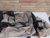 Photo of the large beige backpack showing front and top compartments and straps.