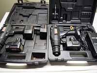 Two Craftsman cordless drills, battery charger, and four batteries inside their carrying cases.