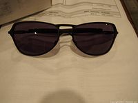 Close-up image of black Oakley Felon sunglasses showing front view with dark lenses on top of an Oakley packing list document.