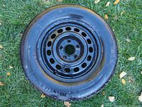 Single Michelin X-Ice studless tire mounted on a 5 bolt black steel rim, showing overall condition and rim details.