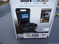 Original retail box showing Shark IQ Robot Self-Empty XL branding and features.
