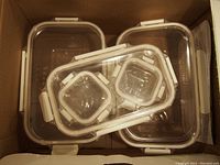 Top view of 5 clear plastic containers stacked inside each other, showing lids and locking clips