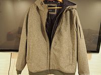 Full frontal view of the grey Tommy Hilfiger windbreaker jacket with front zipper and side pockets.