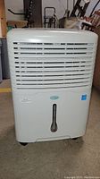 Front view of white Air King dehumidifier with vent grille and water level indicator.