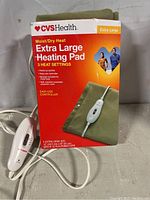 Photo of the heating pad box showing the CVS Health brand, extra large size, and details about moist/dry heat and 3 heat settings.