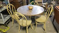 Full view of round table with four matching chairs around it in a storage setting