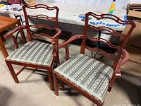 Photo showing both Queen Anne style armchairs side by side, highlighting cherry wood frames and fabric seats.