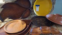All used serving platters together on countertop showing variety of materials and shapes