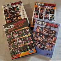 Four sets of Modern Drummer Festival DVDs from various years arranged on table